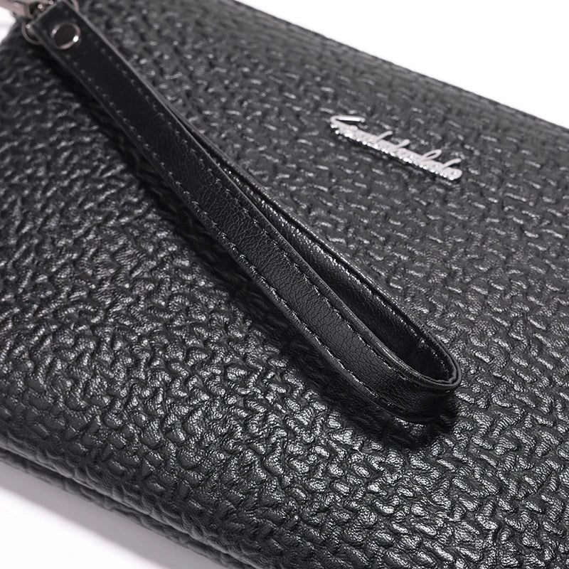Nahaufnahme einer schwarzen Kunstledertasche für Herren mit silbernem Logo und schwarzem Riemen.