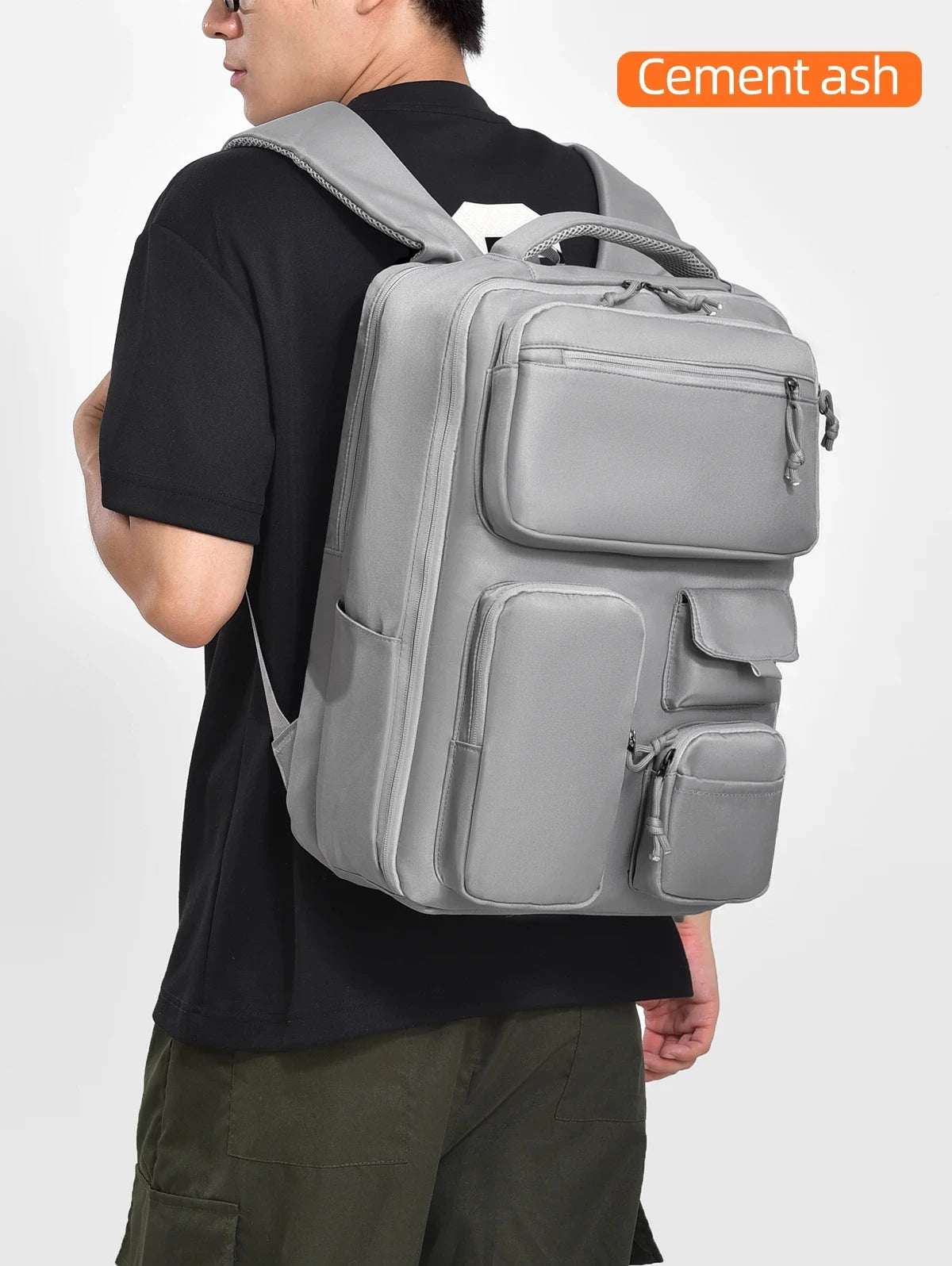 A person is wearing a gray cement ash large capacity travel backpack.