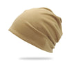 A beige slouchy knit beanie hat shown from the side.