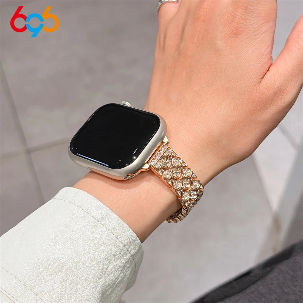 A close-up of a hand wearing a black Apple Watch with a sparkling crystal fishscale metal strap.