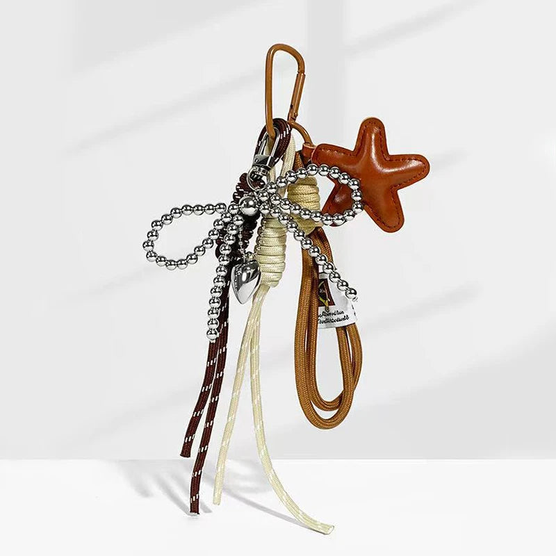 A collection of leather and silver bowknot charms, including a star shape, hanging from a cord.