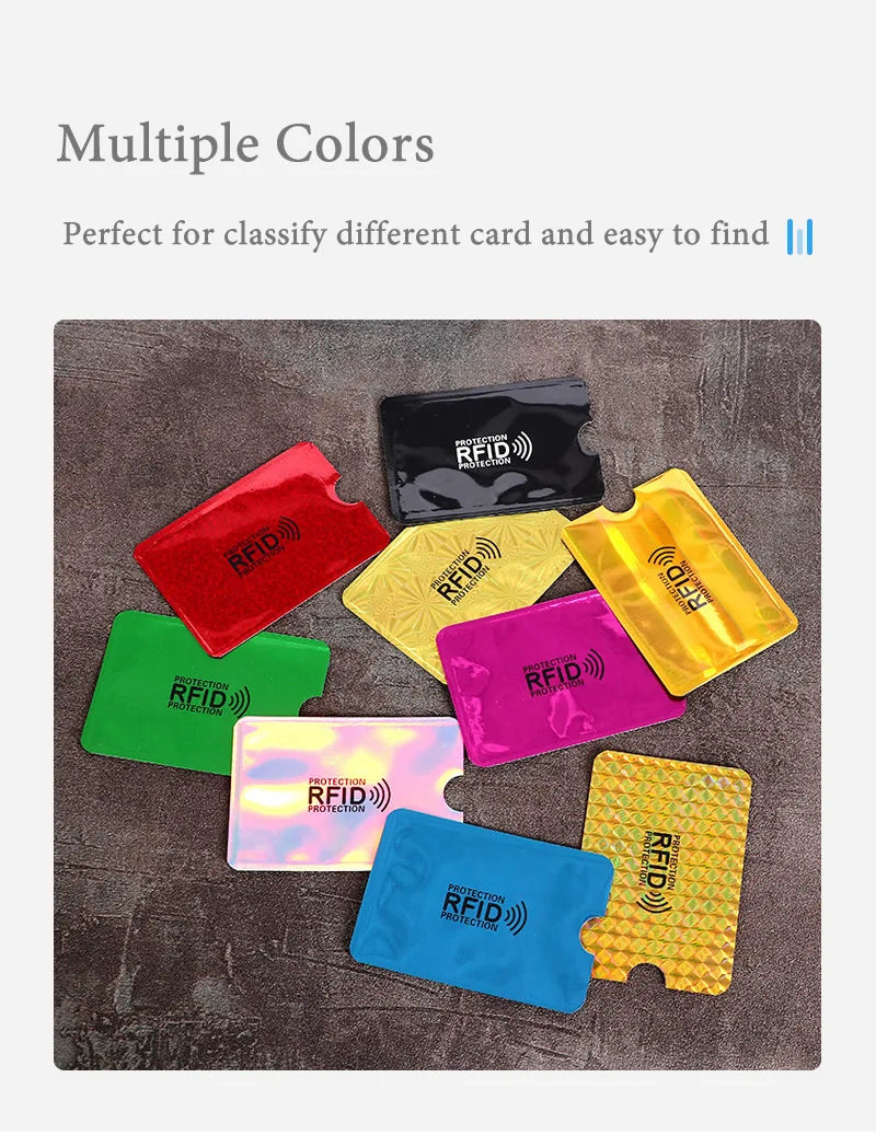 A collection of multiple colored anti-scan card sleeves for RFID protection laid out on a dark surface.