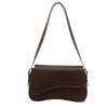 A brown vintage curved flap shoulder bag made of soft faux leather with a long strap.