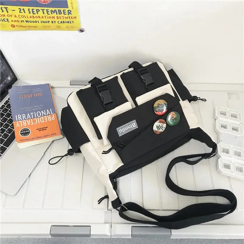 A black and white nylon crossbody shoulder bag is displayed on a white surface.