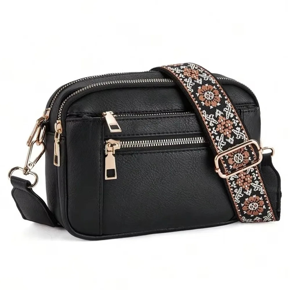 Black PU leather crossbody bag with a patterned strap and gold hardware.