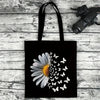 Black canvas tote bag featuring a white daisy with small white butterfly silhouettes.