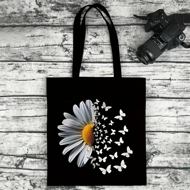 Black canvas tote bag featuring a white daisy with small white butterfly silhouettes.