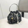 A black crystal-embellished evening clutch with a silver chain handle resting on a white surface.
