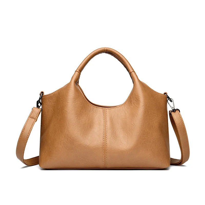 A tan leather women's casual crossbody shoulder bag with a zip closure.