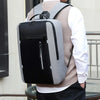 A person is carrying a gray and black durable laptop backpack over their shoulder.