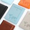 A collection of leather passport holders in blue, orange, and brown colors displayed on a white surface.
