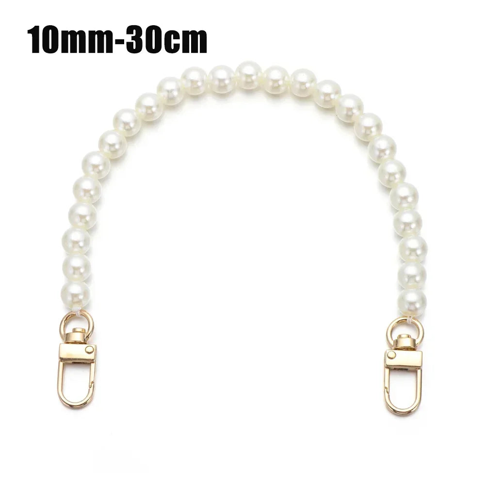 A strand of white pearls used as a strap for a handbag or purse.