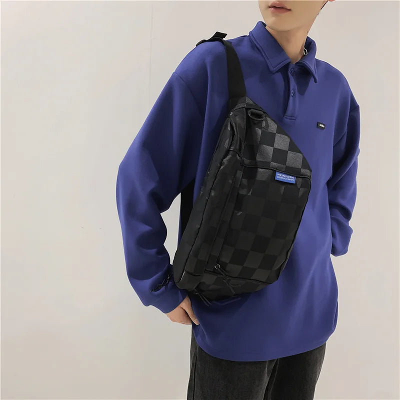 Person in royal blue shirt and dark pants carrying a black checkered chest bag.