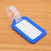 A blue luggage tag with a clear plastic holder and a strap, lying on a wooden surface.