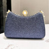 A dark blue glittery evening clutch featuring gold rhinestone embellishments and a decorative clasp.