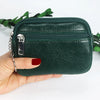 A dark green compact PU leather mini wallet with a silver keychain is held in a hand.