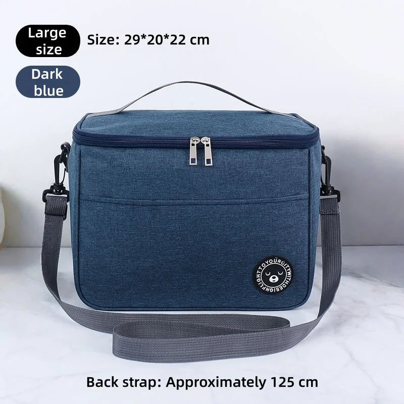 Dunkelblaue isolierte Thermotasche mit schwarzem Riemen vor weißem Hintergrund.