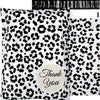 A white fabric pouch with a black leopard print design and a thank you label.