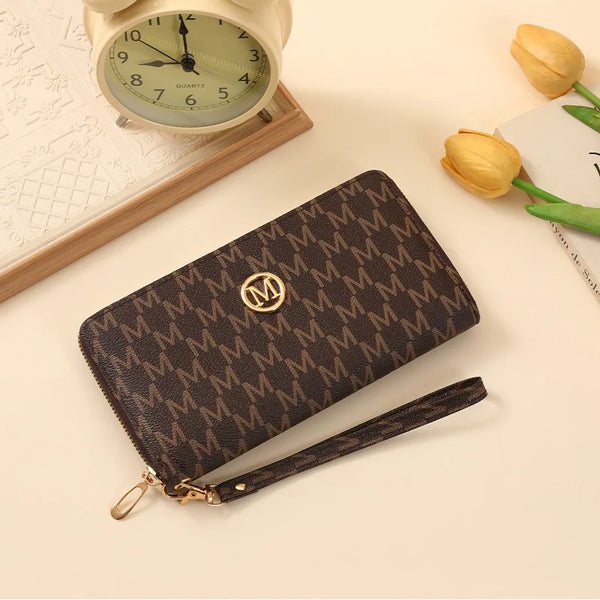 Portefeuille à fermeture éclair en cuir marron foncé monogrammé, posé à côté d'une montre vintage et d'une rose jaune.