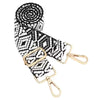 A black and white patterned nylon crossbody bag strap coiled for display.