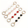 A set of gold-toned metal chain shoulder straps with heart-shaped extensions in pink and red colors.