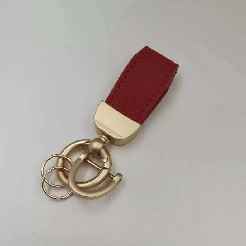 Maroones Leder-Anhänger mit Messingverschluss und goldfarbener Kette.