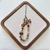 Leopard print bowknot phone lanyard featuring heart-shaped beads and a decorative bow.