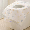 A white disposable toilet seat cover is shown rolled up, featuring gold and blue leaf patterns.
