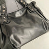A black leather shoulder bag with silver hardware and a flap closure shown from the front.