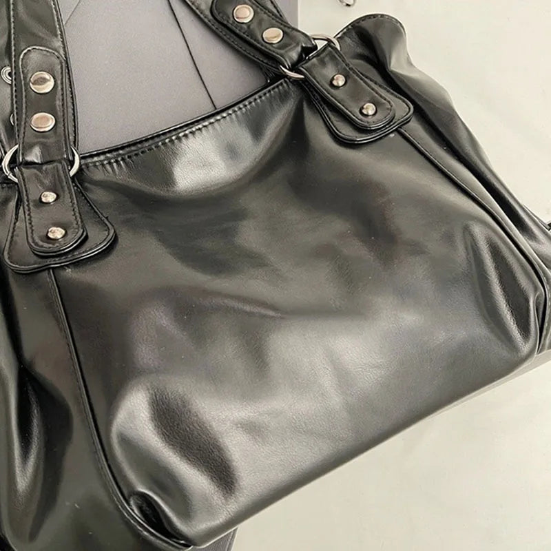 A black leather shoulder bag with silver hardware and a flap closure shown from the front.