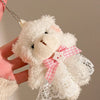 A white plush bear keychain featuring a camera and glasses, held by a hand.