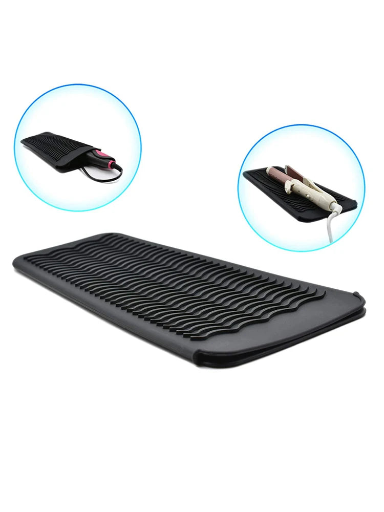 Black heat-resistant silicone mat with grooves for styling tools and a cord.