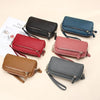 A collection of genuine cowhide leather double-zip wristlet wallets in shades of black, navy blue, maroon, and gray.