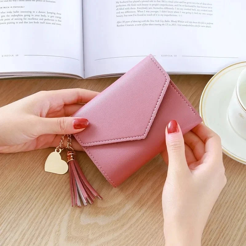 A hand holds a pink waterproof nylon crossbody bag with gold tassel and a light green plate.