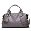 A gray faux leather Boston handbag with a curved handle and flap closure.