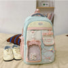 A light blue and pink Candy Color Campus backpack for women sitting on a beige surface.