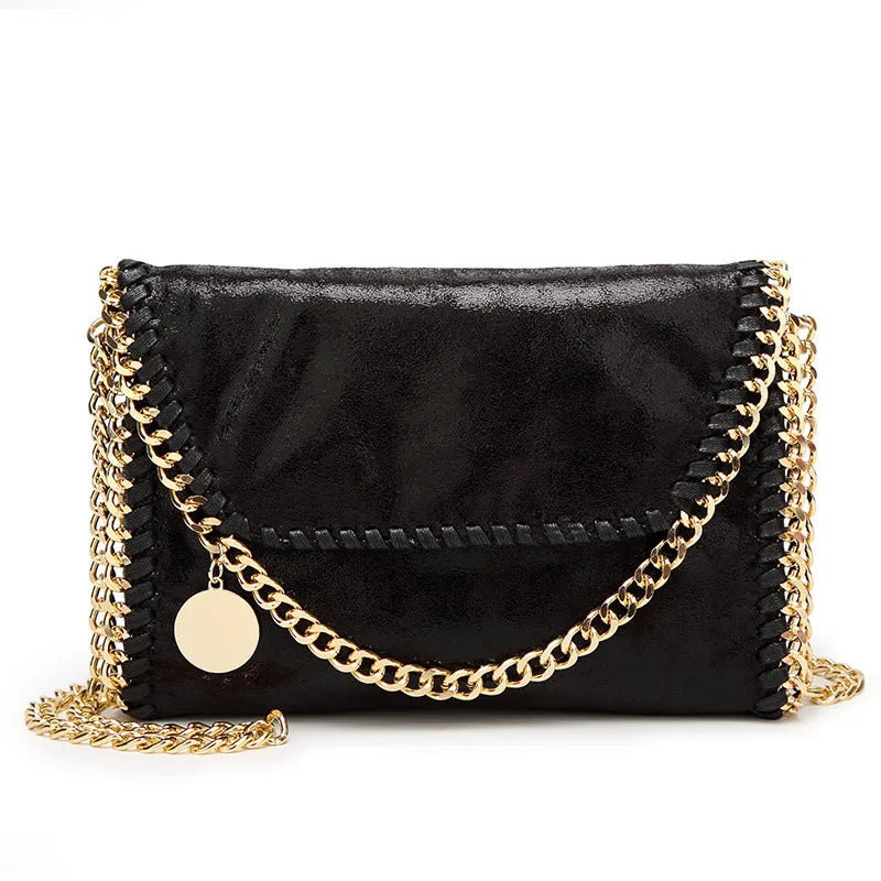 Black velvet flap crossbody bag with a gold chain strap