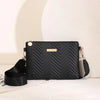A black quilted leather crossbody bag with gold hardware resting on a white surface.