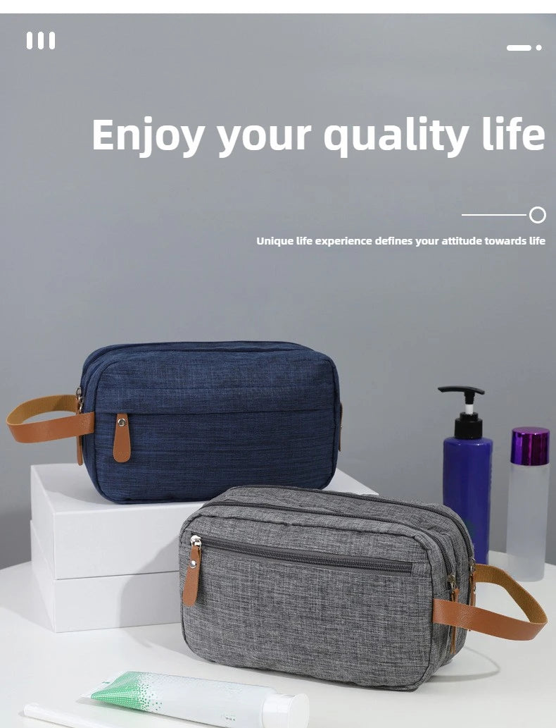 A navy blue and gray portable travel storage pouch for cosmetics is displayed on a white surface.