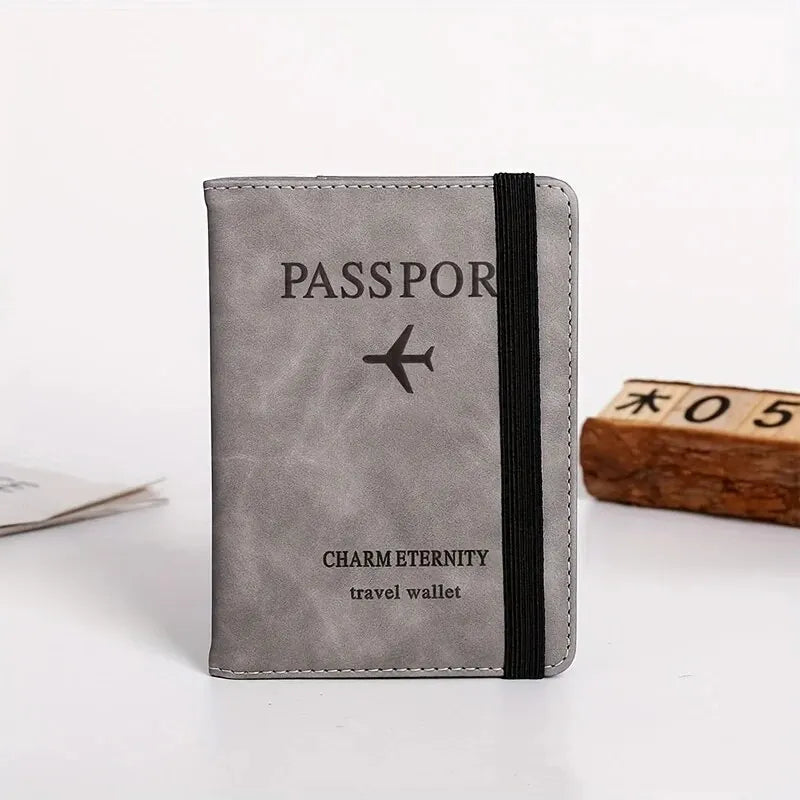 A grey passport wallet with black stitching and a black strap, featuring the text charm eternity and travel wallet.