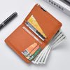 An orange slim faux leather business card wallet holding several credit cards and a pen.