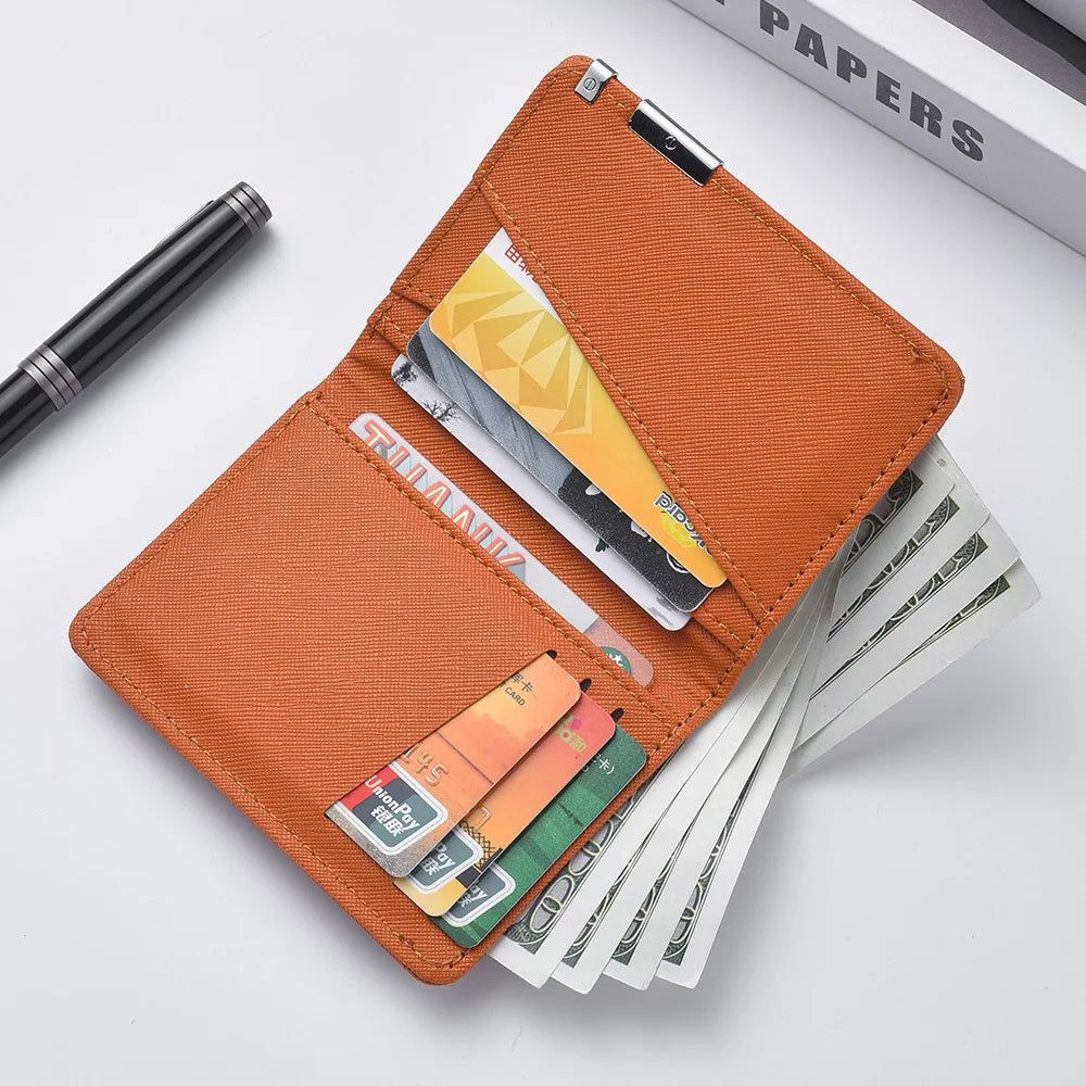 An orange slim faux leather business card wallet holding several credit cards and a pen.