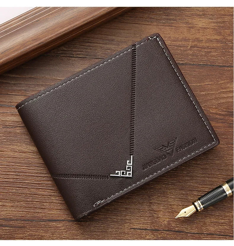 A dark brown leather bifold wallet with stitching and a gold pen resting on a wooden surface.
