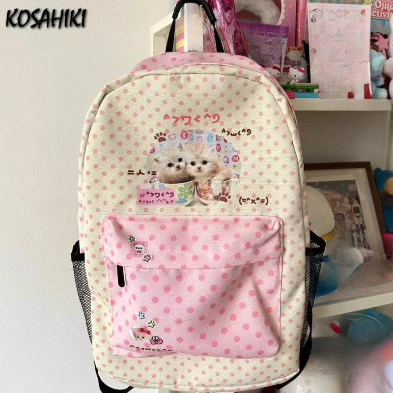 Sac à dos rose et blanc à motifs de chats mignons avec une poche avant rose.