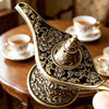 Antique metal incense burner with intricate floral patterns resting on a wooden table.