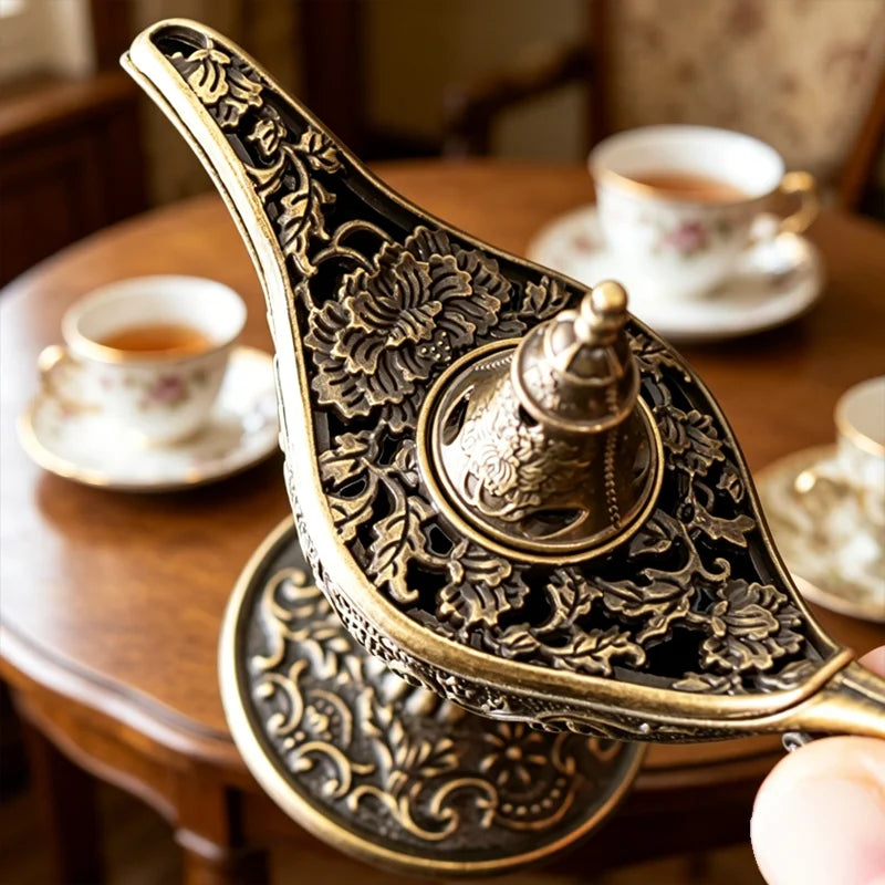 Antique metal incense burner with intricate floral patterns resting on a wooden table.