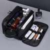 Sac de toilette en cuir PU noir pour homme contenant des produits de soin et une bouteille de cologne.