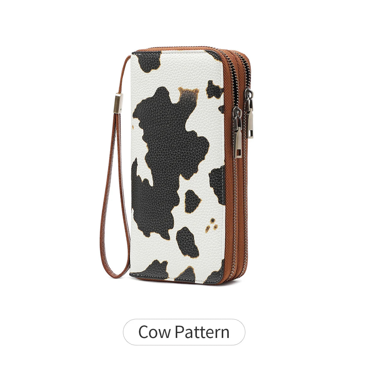 A brown and white cow pattern tri-fold wallet with a zipper and wrist strap.