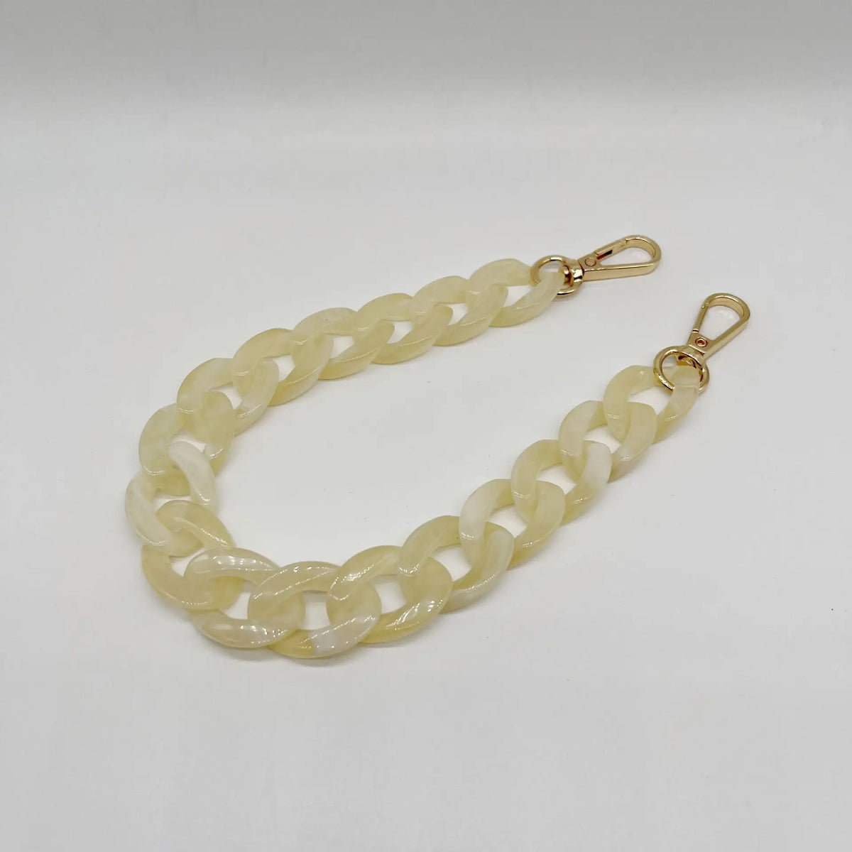 A light yellow acrylic chain bracelet with a gold-colored clasp.