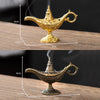 A golden antique metal incense burner with a spout and handle sits on a wooden surface.